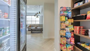 A grocery store with refrigerated sections and shelves stocked with snacks and beverages.