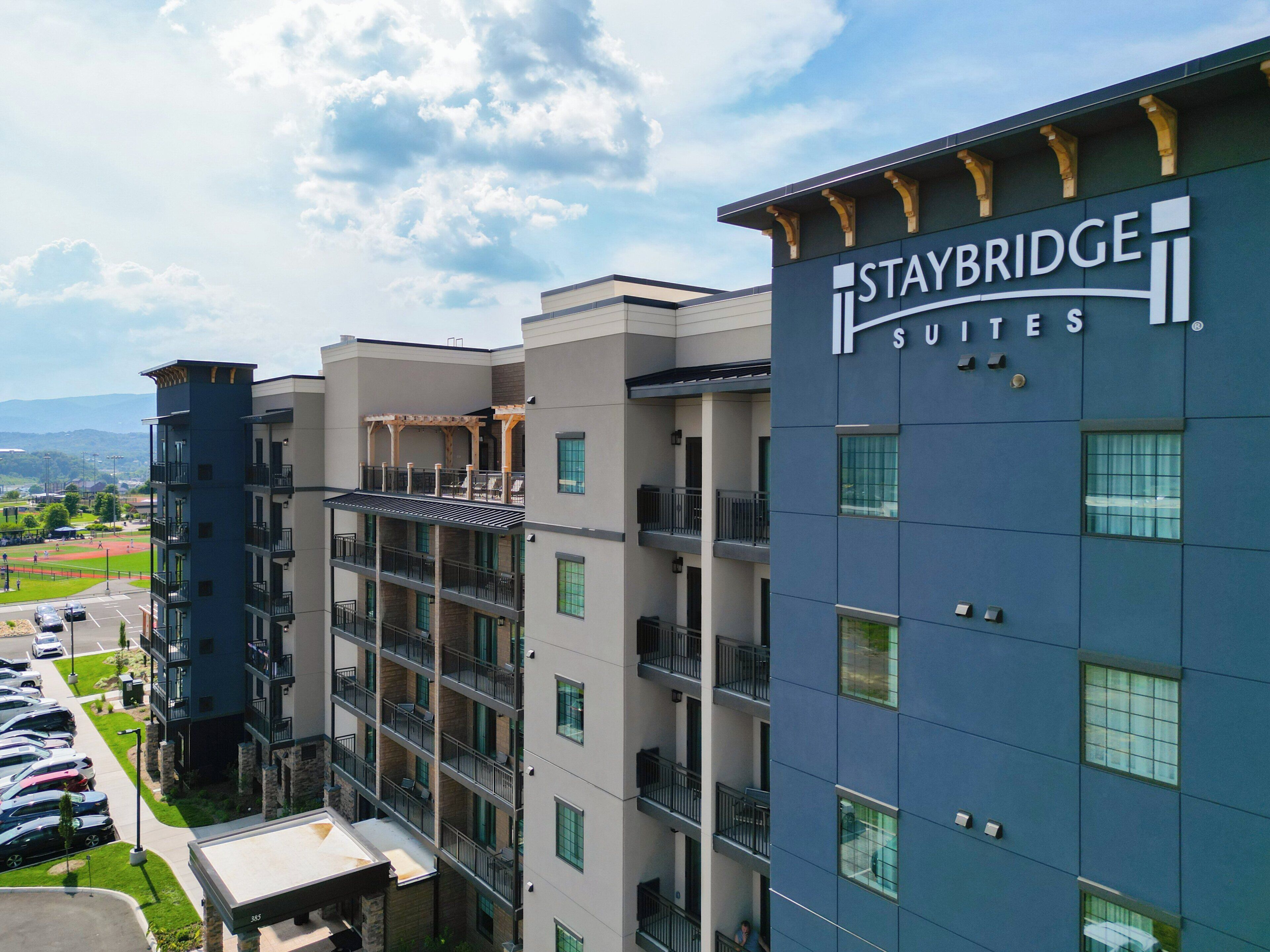 Un hôtel à plusieurs étages, avec une enseigne indiquant « Staybridge Suites ».