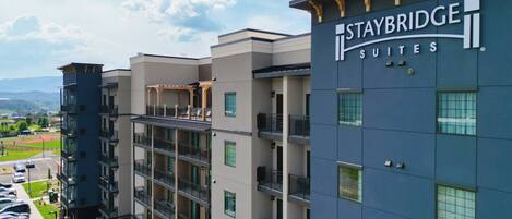 Un hôtel à plusieurs étages, avec une enseigne indiquant « Staybridge Suites ».