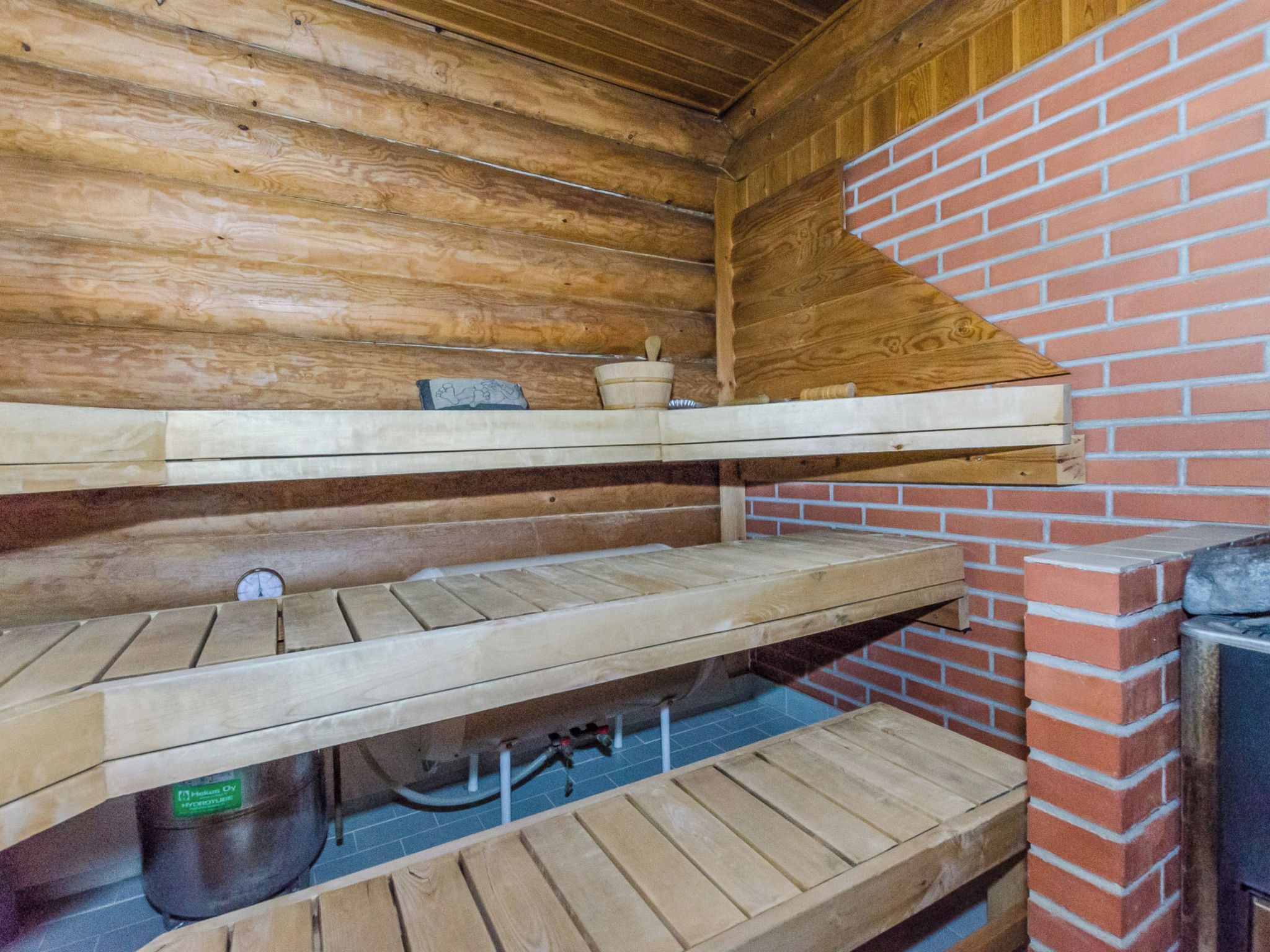 A wooden interior with a brick wall and shelves.