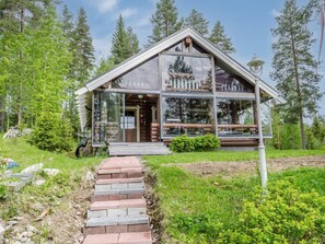 Stunning log cabin-style building with a glass facade, surrounded by lush greenery.