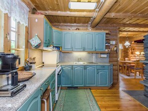 Cocina con gabinetes color turquesa, encimera de granito y techo de madera.