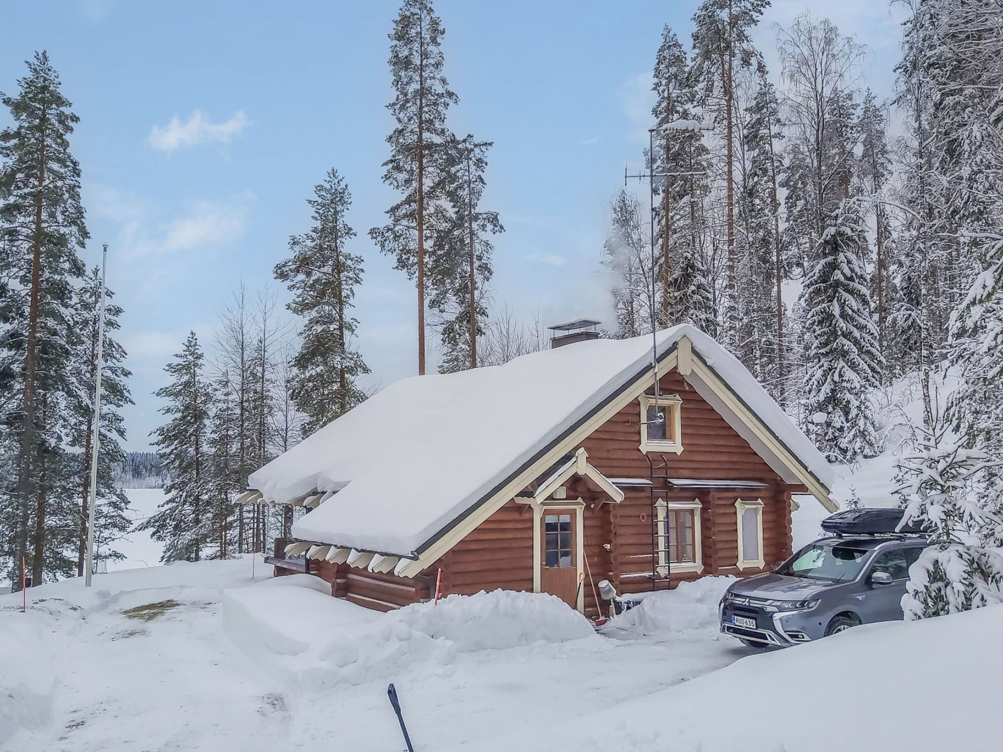 A log cabin surrounded by snow-covered trees.