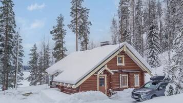 A log cabin surrounded by snow-covered trees.