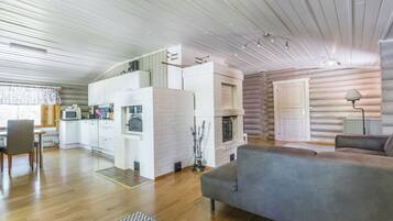 Interior moderno de una cabaña de troncos con cocina, comedor y sala de estar.
