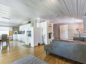 Ein modernes Blockhaus-Interieur mit Küche, Essbereich und Wohnzimmer.