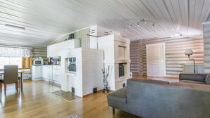 Un intérieur chaleureux de chalet en bois, comprenant une cuisine, un coin repas et un salon.