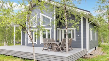 A modern house with a deck and outdoor furniture.