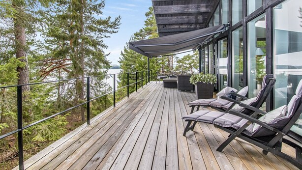 A wooden deck with outdoor seating and a view of the water.