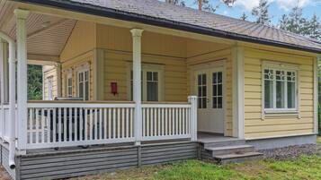 A single-story yellow house with a porch, a chimney, and a small front yard.