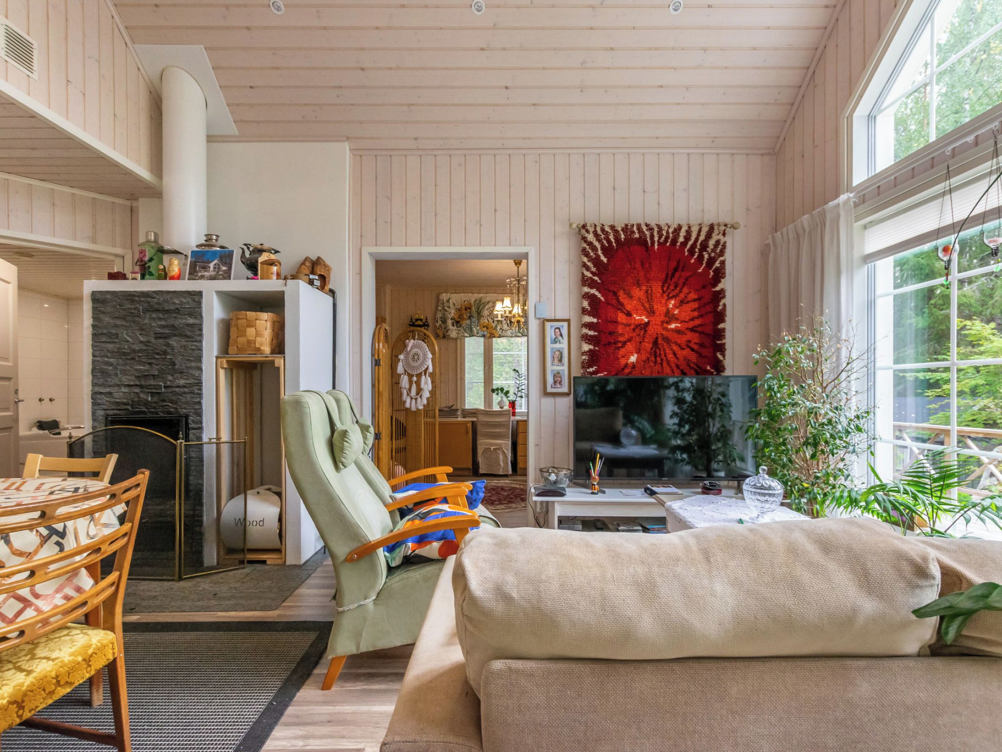 Una sala de estar acogedora con chimenea, un televisor grande y una llamativa decoración roja en la pared.