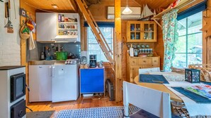 Interior acogedor de una cabaña con cocina, comedor y un amplio ventanal.