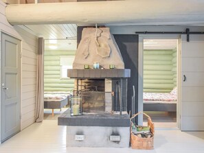 Una habitación con chimenea, cama, puerta y ventana.
