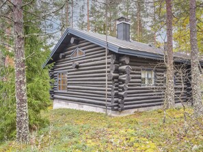 A log cabin with a chimney, windows, and a porch. - Metsätupa by Interhome (Raasepori)