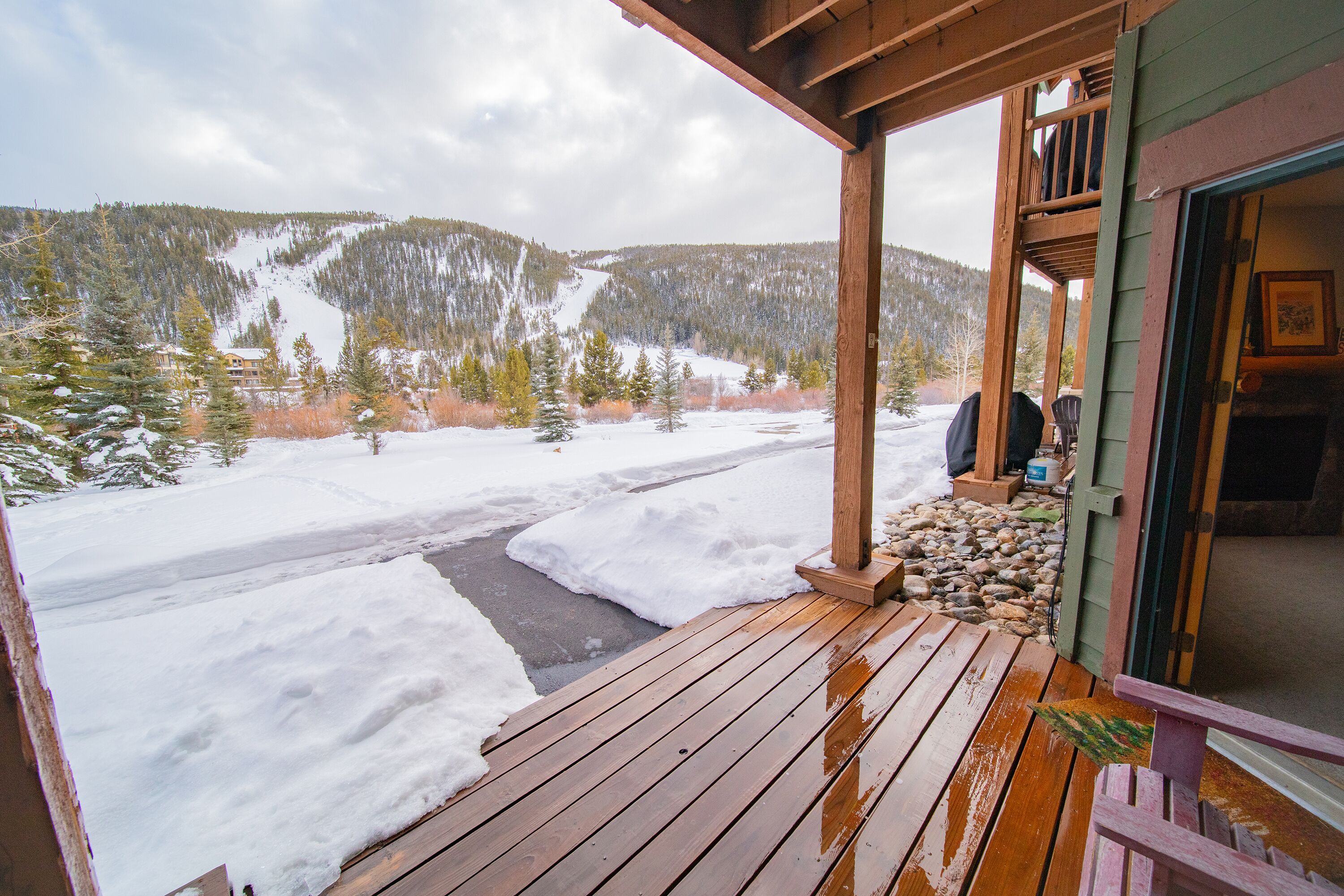 A wooden deck with a view of a snowy mountain landscape.