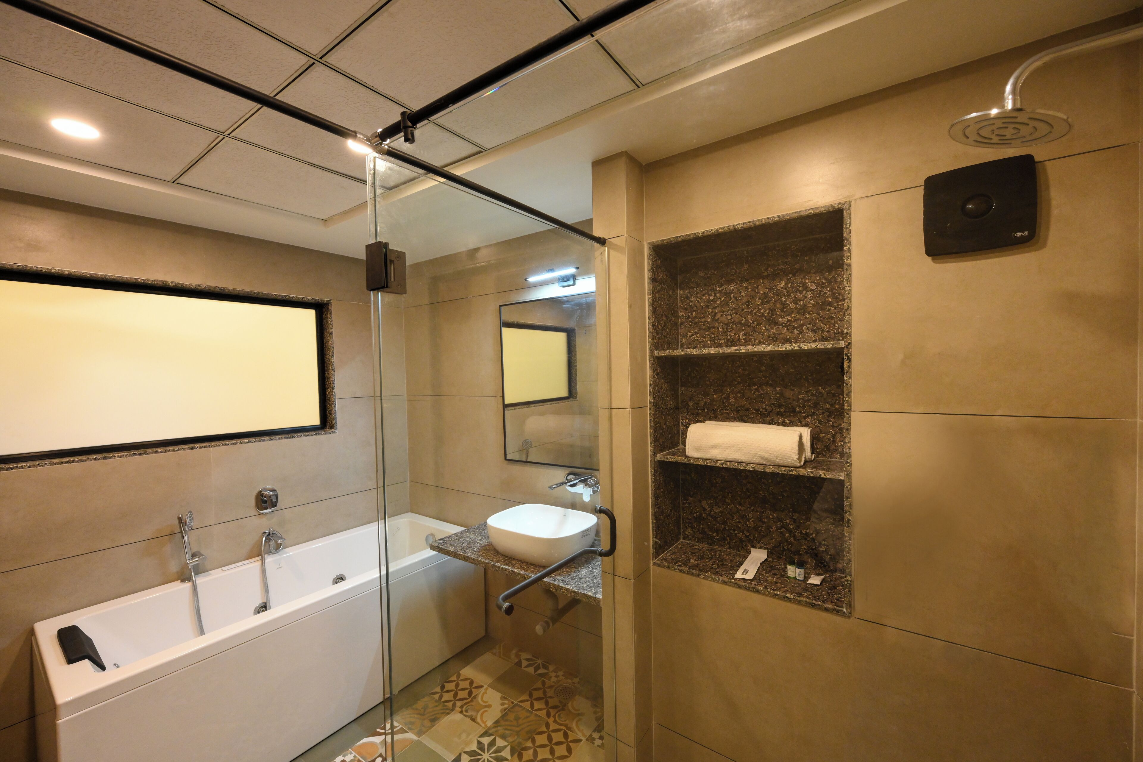 Un baño moderno con ducha envuelta en vidrio, una bañera independiente y un lavamanos con lavabo y espejo.