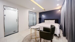 A modern hotel room with a bed, a chair, a small table, and a wardrobe. - ONNA HOTEL (Busan)