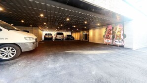 A parking garage with three cars parked in the center. - ONNA HOTEL (Busan)