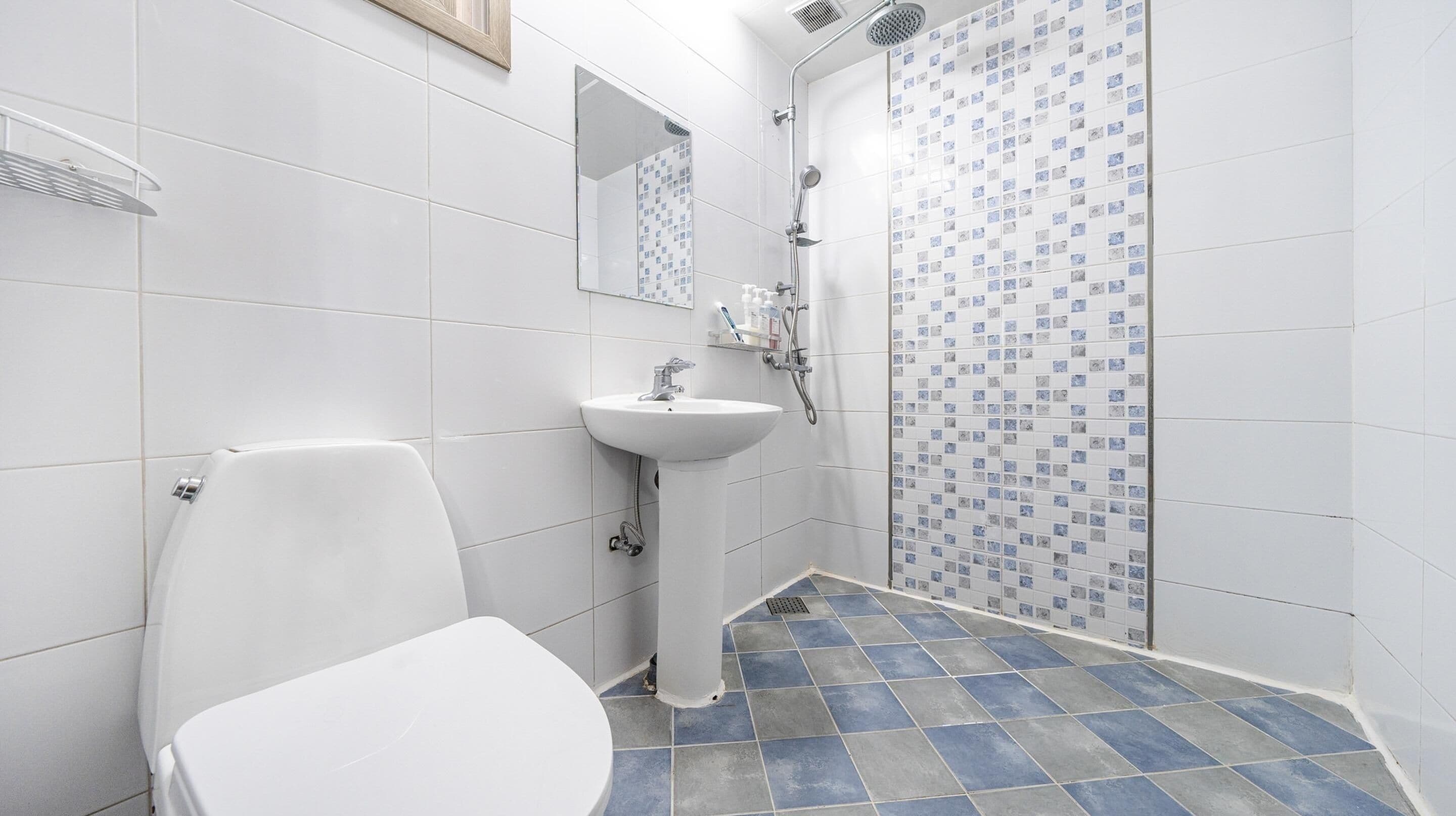 Un baño con inodoro, lavamanos y ducha.