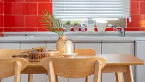 Una mesa de comedor de madera con sillas, un florero con una planta y una vela.