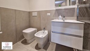 Une salle de bain moderne équipée de toilettes, d’un bidet et d’un meuble-lavabo.