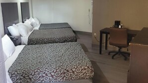 Een hotelkamer met twee bedden, een bureau, een stoel en een kledingkast.