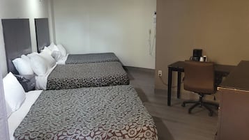 Una habitación de hotel con dos camas, un escritorio, una silla y un armario.