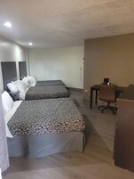 Una habitación de hotel con dos camas, un escritorio, una silla y un armario.