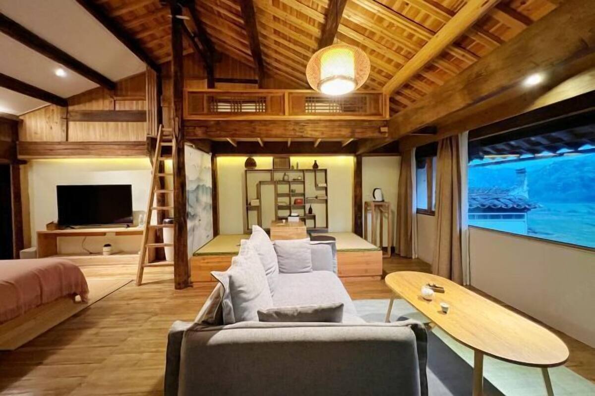 A modern interior with a wooden ceiling, a sofa, a TV, and a table.