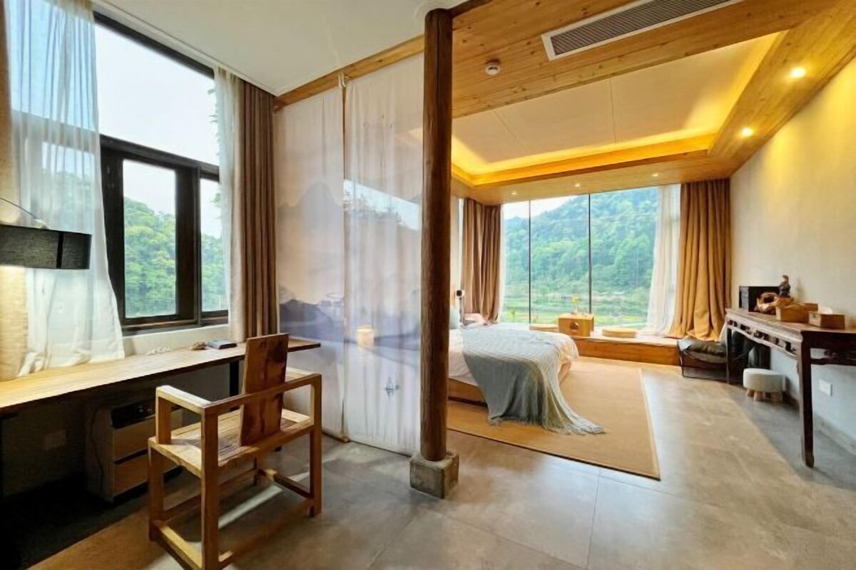 Una habitación con cama, escritorio y vistas al exterior.