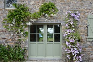 Experience a traditional stay in this charming stone building with a cozy green door and lush garden.