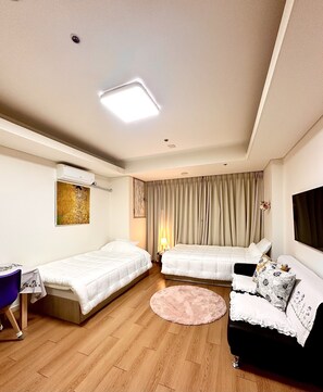 Relax in this stylish room with two single beds, a sofa, and a flat-screen TV.