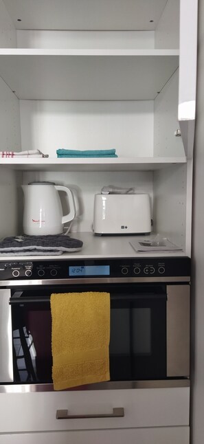 Een koelkast, een oven, een kookplaat, een koffiezetapparaat/waterkoker