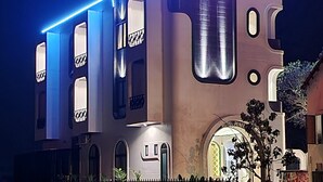 A building with a modern design, featuring a prominent 'HOTEL' sign and a 'PUNITA' sign. - Punita Hotel (Da Nang)