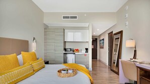Une chambre d’hôtel avec un grand lit, un bureau et une kitchenette.