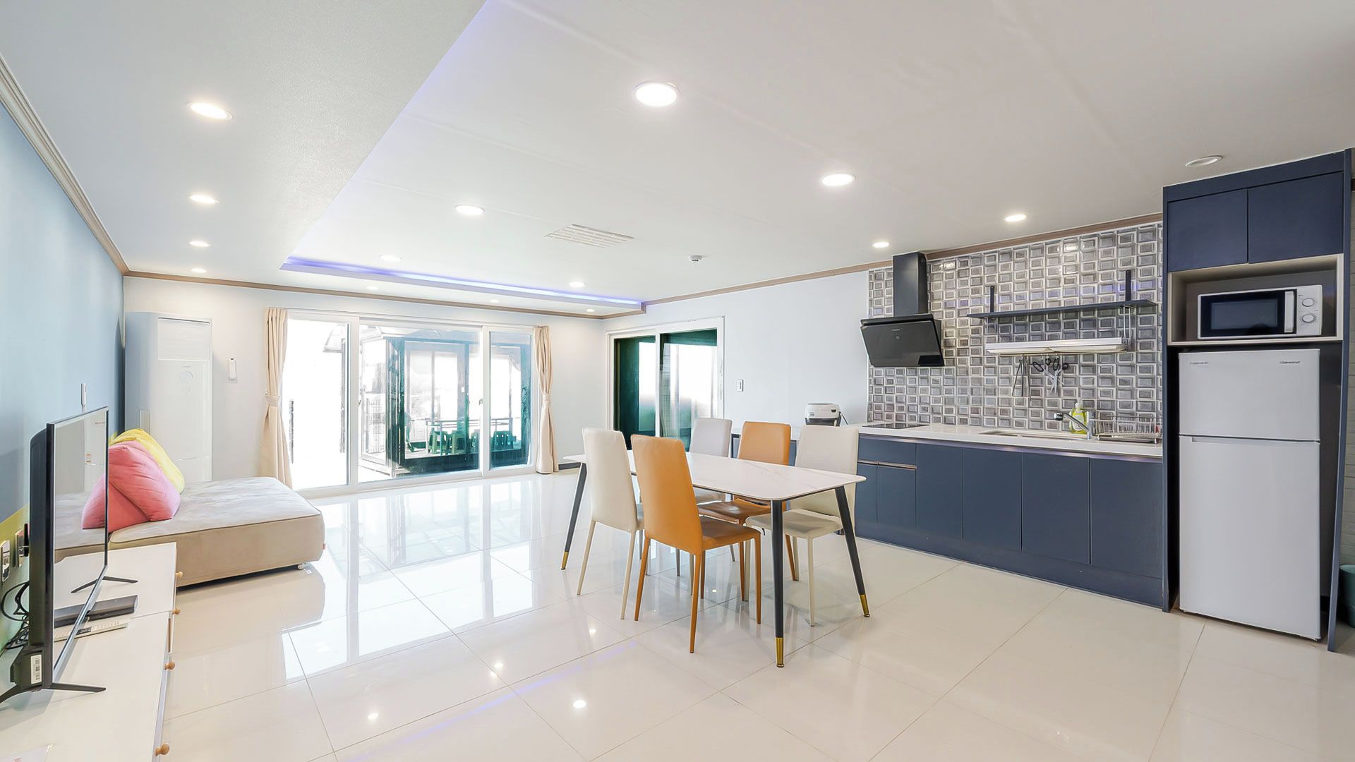 Una cocina moderna con comedor, ventanas amplias y vistas al exterior.