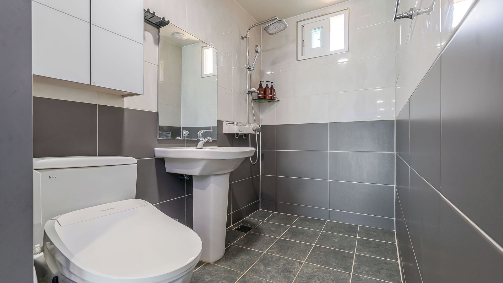 Un baño con inodoro, lavabo y ducha.