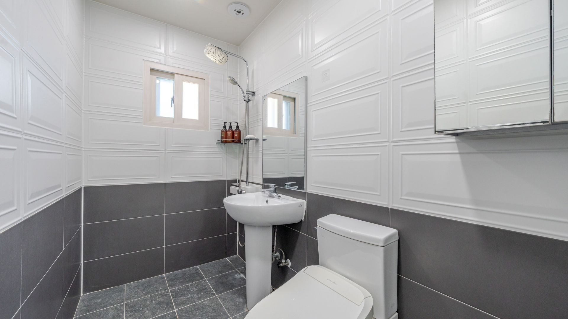 A bathroom with a white sink, a toilet, and a shower.