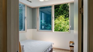 A bedroom with a bed, a window, and a small bedside table. - Taean Blueisland Pool Villa (Taean)