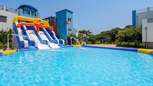 Una piscina con tobogán de agua, rodeada de edificios modernos.