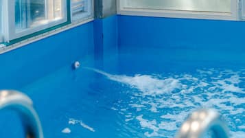 Una piscina con baldosas azules y un desagüe visible.