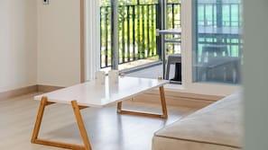 Una habitación minimalista con una mesa blanca, dos tazas blancas y una silla de madera.