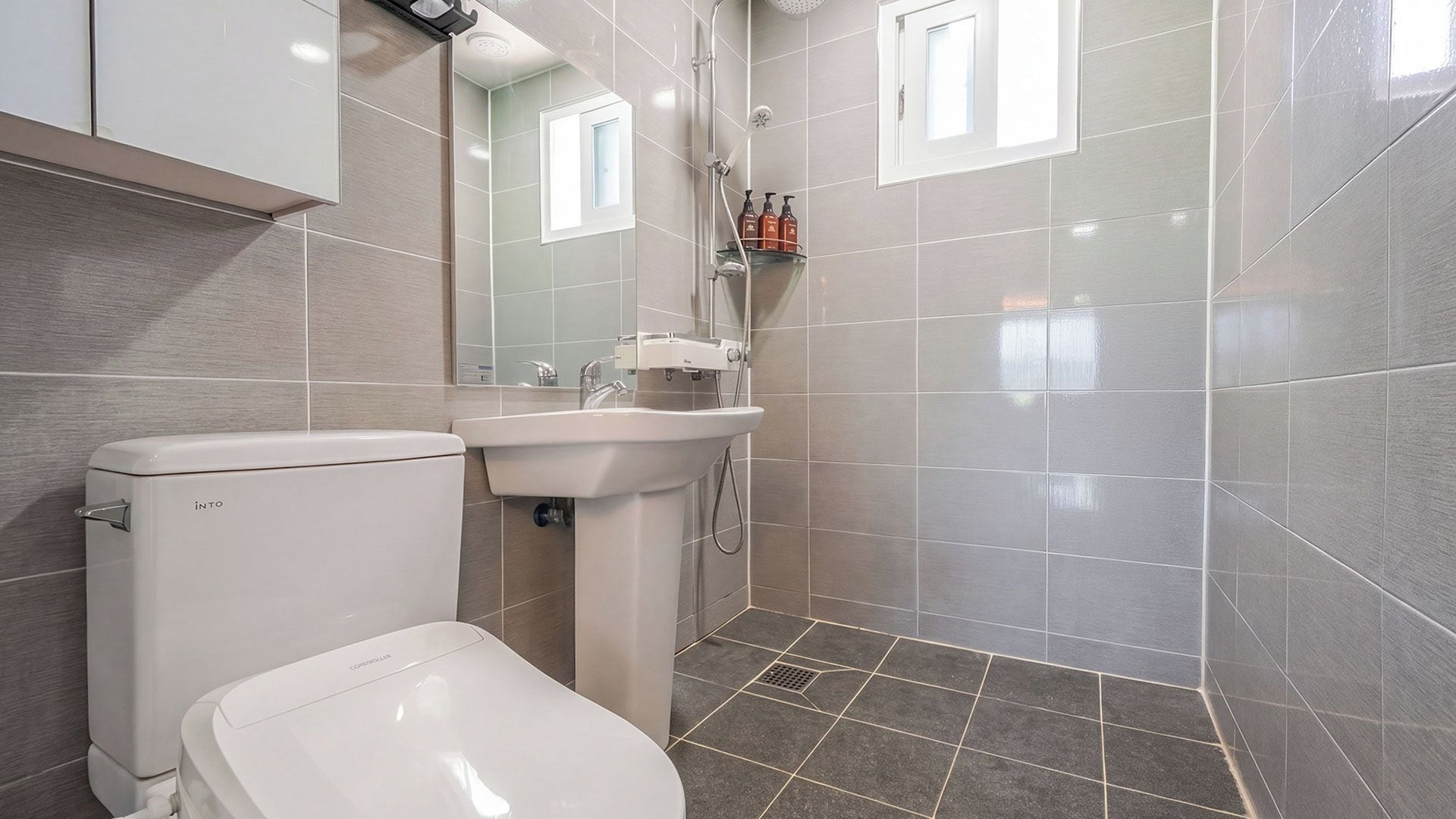 Une salle de bain moderne équipée de toilettes, d’un lavabo et d’une douche.