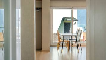 Una habitación con puerta corrediza de vidrio que da a un balcón con mesa y sillas.