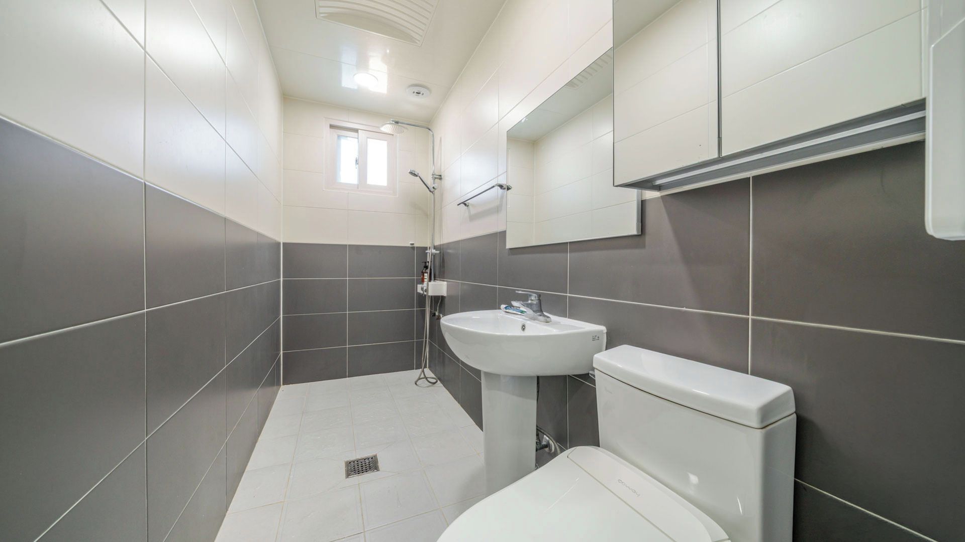 A modern bathroom with a toilet, sink, and shower.