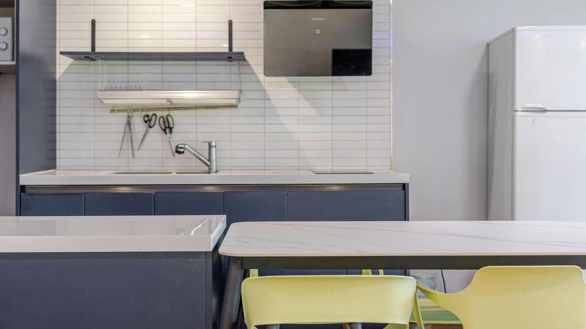 A modern kitchen with a built-in microwave, a sink, and a refrigerator.