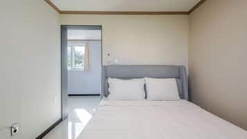 Un dormitorio con cama, una puerta que da a un balcón y un interruptor de luz en la pared.