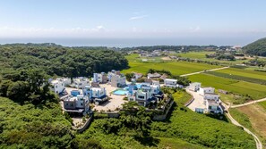 A residential area with modern houses, a swimming pool, and surrounding greenery. - Taean Blueisland Pool Villa (Taean)