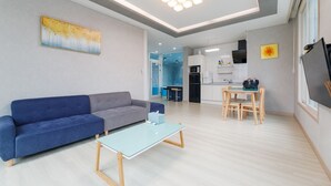Una sala de estar moderna con un sofá, una mesa de centro y un comedor con una mesa y sillas.