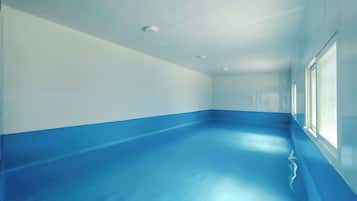 A room with a blue floor, white walls, and a window on the right.